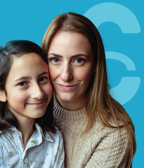 Woman and her daughter in front of blue backdrop with stylized "S"